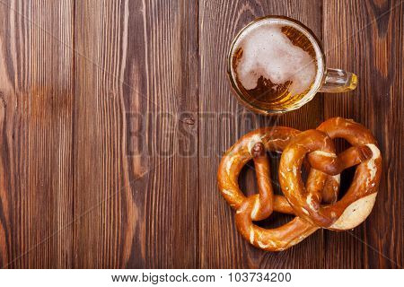 Beer mug and pretzel on wooden table. Top view with copy space