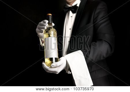 Waiter In Tuxedo Holding A Bottel Of White Wine