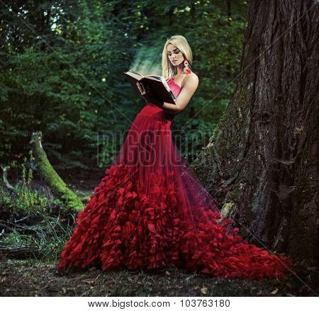 Beautiful blonde reading a book in a forest
