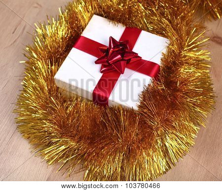 New Year gift on a golden tinsel background boly