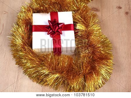 New Year gift on a golden tinsel background boly