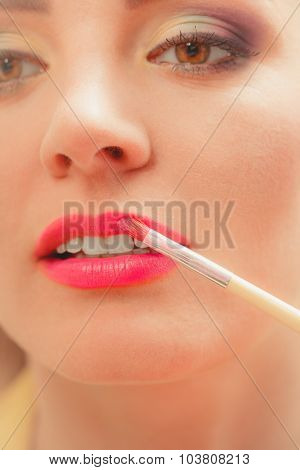 Woman Applying Lipstick With Brush On Lips. Makeup