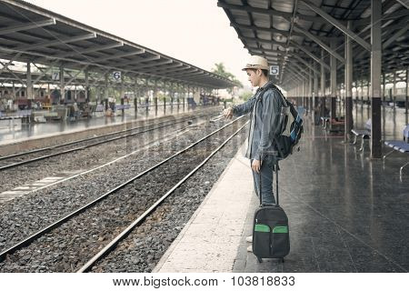 Train Delay. Young Asian Man Looking In His Watch While Waiting Train At Station