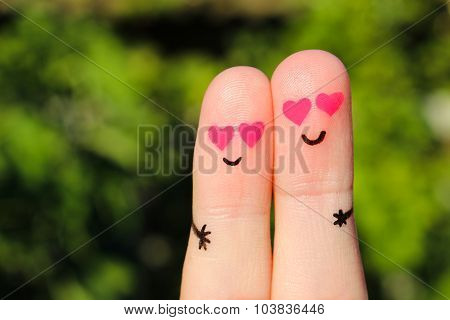 Finger art of a Happy couple. A man and a woman hug with pink hearts in the eyes.