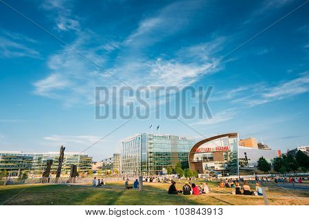 People are relaxing in front of the Kiasma museum and Sanoma bui