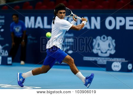KUALA LUMPUR, MALAYSIA - SEPTEMBER 26, 2015: Syed Mohd Agil of Malaysia plays a backhand shot in his qualifying match in the Malaysian Open 2015 Tennis tournament held at the Putra Stadium, Malaysia.