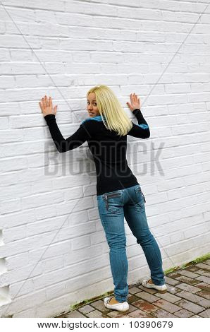 Flicka kostnader om en vit vägg