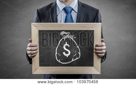 Unrecognizable businessman holding blackboard with drawn dollar concept