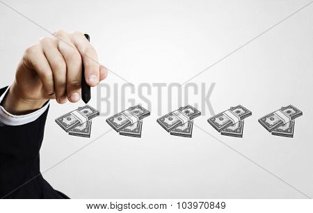 Close up of businessman drawing money making formula