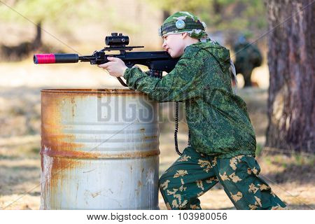 Boy with a gun playing lazer tag open air