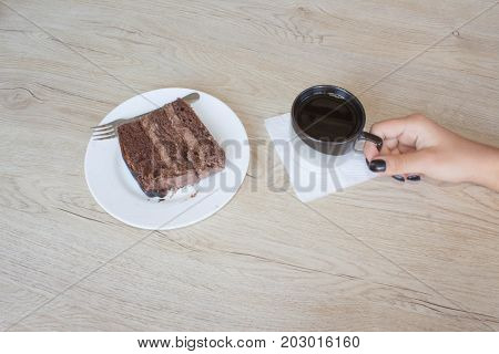 Coffee cup and chocolate cake onon wooden table. Coffee and a piece of cake.