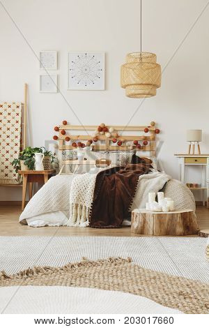 Big hand-made bed with warm blankets thrown on it