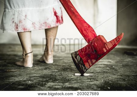 Asian girl dress killer to Halloween festival She holds a giant axe soaked with blood with scary eyes ready to kill people.