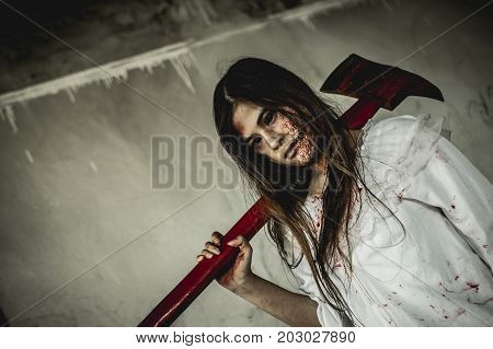 Asian girl dress killer to Halloween festival She holds a giant axe soaked with blood with scary eyes ready to kill people.