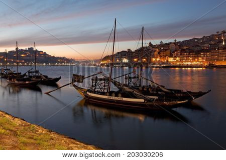 PORTO, PORTUGAL - 07.10.2016, old town cityscape on the Douro River with traditional Rabelo boats, with barrels advertising Porto alcohol