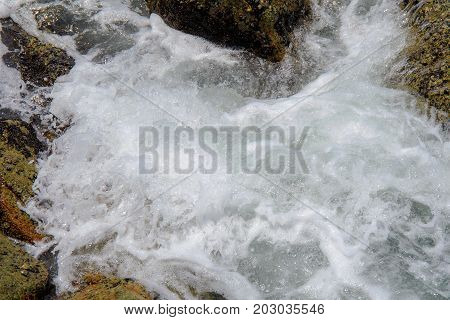 Sea wave with rock at sand beach with high speed shutter.