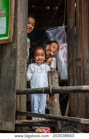 SIHANOUKVILLE CAMBODIA - 7/20/2015: A group of children smile and laugh from their home in a fishing village.