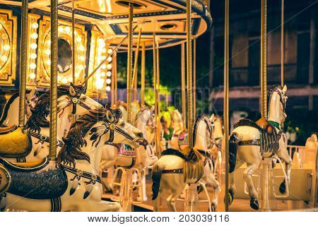 Selective focus to some part flying horse carousel carnival background with Vintage filter.