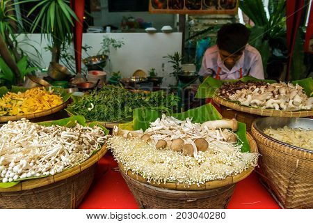 CHIANG MAI THAILAND - 6/13/2015: A cook prepares vegetables for food at the Sunday walking street market.