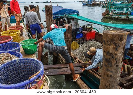 SIHANOUKVILLE CAMBODIA - 7/20/2015: Fishermen prepare for the day in a fishing village.