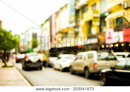 Blurred road with bokeh street of town and cars at Bangkok Thailand for travel background or texture - slow life and vintage color style.