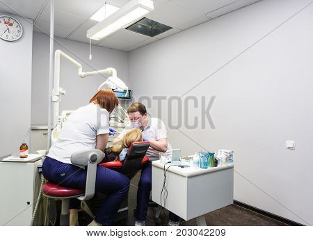Moscow, Russia. June 2017 The dentist and the assistant work on the patient in the clinic