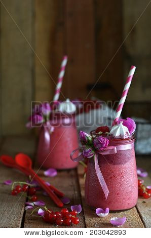 berry smoothies with red currants, strawberries, raspberries, yogurt, meringue and rose petals