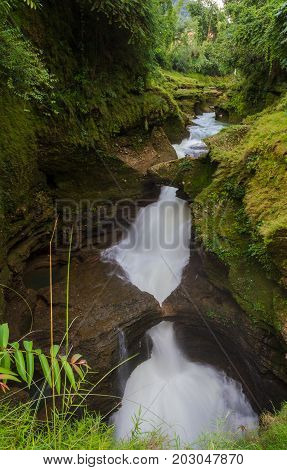 Water flows down Devi's Falls into the Gupteshwar Cave below in Pokhara Nepal.