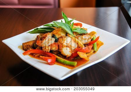 Stir-Fried Spicy Seafood, Stir-fried red curry with shrimp, mussels, scallops, squids, crabmeat, fish balls, bamboo shoots, green beans, basil leaves and eggplant