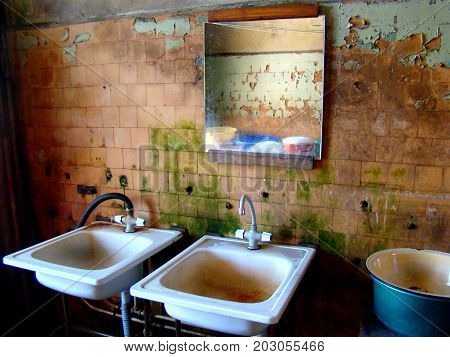 rusty destroyed bathroom sinks in poor house for the poor.