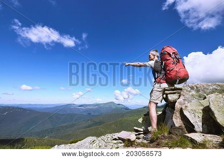 Hiking in the mountains with a backpack in the summer.