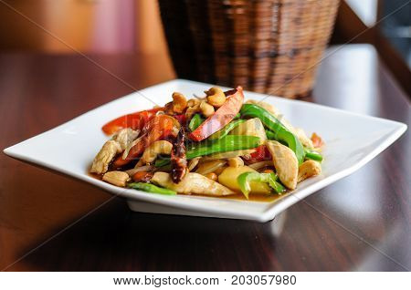 Stir-Fried Cashew Chicken, Slices of chicken breast stir-fried with cashew nuts, peapods, pineapple, onions, tomato ,and bell peppers