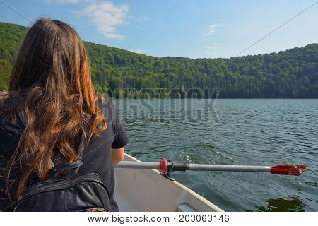 Teen girl back view sailing on lake