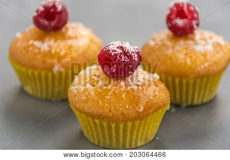 Tasty cupcakes with raspberries and coconut chips