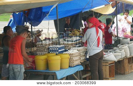 DAVAO ORIENTAL, PHILIPPINES--Sidewalk vendors sell their produce from their makeshift tents at the street market in Banaybanay, Davao Oriental in March 2016. Popular are eggs, anchovy and dried fish.