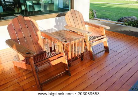 Brown wooden chairs with table set on the wooden floor at Chaolao Tosang beach Chanthaburi - Thailand for background or texture.
