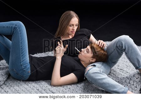 Young Woman Lying On Blanket With Girlfriend