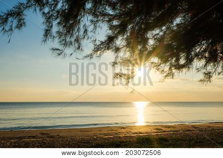 Sunset at sea with trees sway at Chaolao Tosang Beach Thailand.