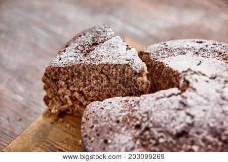 Delicious chocolate cake in white plate on wooden table background, closeup