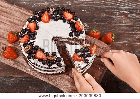 Closeup of Making Sponge Cake with Strawberry. Hand putting icing on freshly baked cake