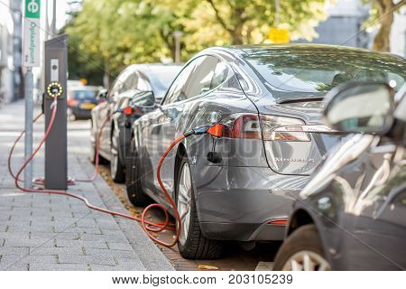 ROTTERDAM, NETHERLANDS - August 06, 2017: Tesla model S charging on the street in Rotterdam. This car is a full-sized all-electric five-door, luxury liftback, produced by Tesla, Inc