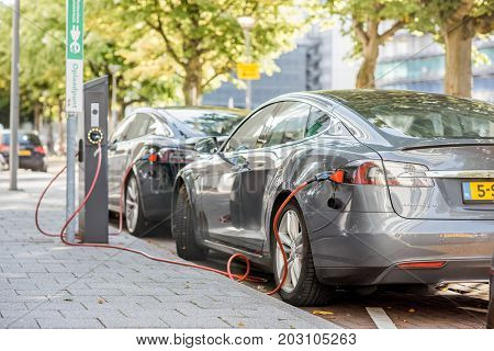 ROTTERDAM, NETHERLANDS - August 06, 2017: Tesla model S charging on the street in Rotterdam. This car is a full-sized all-electric five-door, luxury liftback, produced by Tesla, Inc