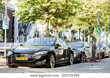 ROTTERDAM, NETHERLANDS - August 06, 2017: Tesla model S charging on the street in Rotterdam. This car is a full-sized all-electric five-door, luxury liftback, produced by Tesla, Inc