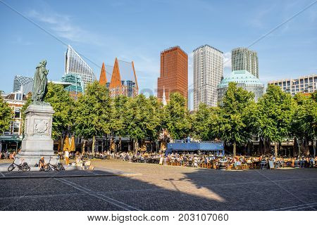 HAAG, NETHERLANDS - August 06, 2017: View on the Plein square with statue of William and modern skyscrapers on the background during the sunset in Haag city