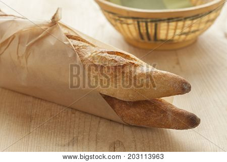 Two French baguettes parisienne wrapped in paper