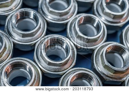 Plumbing connection fittings for plastic pipes. Orderly arranged in neat rows. Abstract industrial background.
