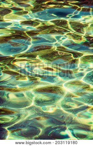 Rippled water surface with natural reflections. Yellow photo filter.
