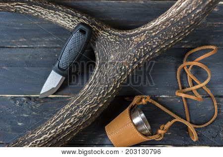 Small Hunting Knife And A Glass In A Leather Case. The Horn Of A Deer.