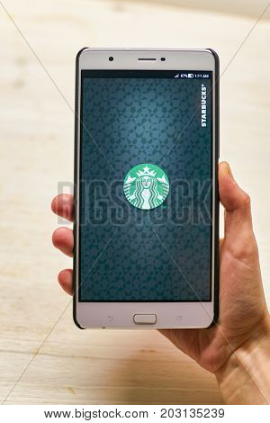 KALININGRAD, RUSSIA - CIRCA SEPTEMBER, 2017: Starbucks app opening screen on Asus Zenfone 3 Ultra smartphone. Starbucks Corporation is an American coffee company and coffeehouse chain.