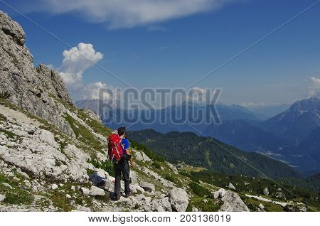 Young maie trekker hiking on a trail in the Dolomites Italy range of Marmarole